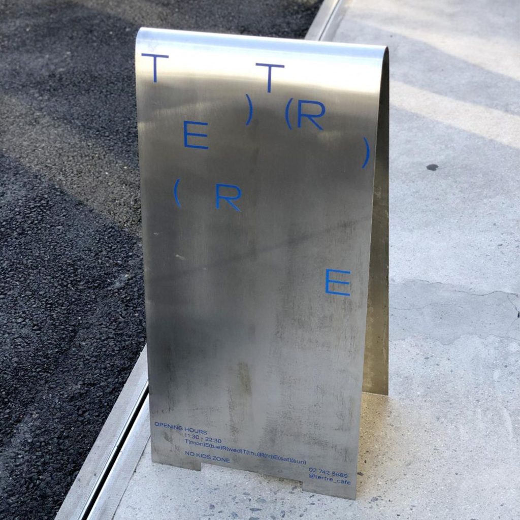 Impression de lettres en UV sur une plaque inox transformée en chevalet