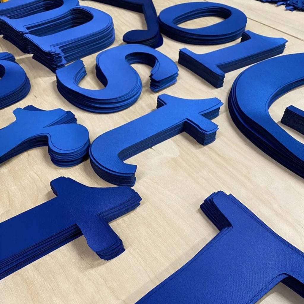 Lettres découpées au laser CO₂ dans du tissu